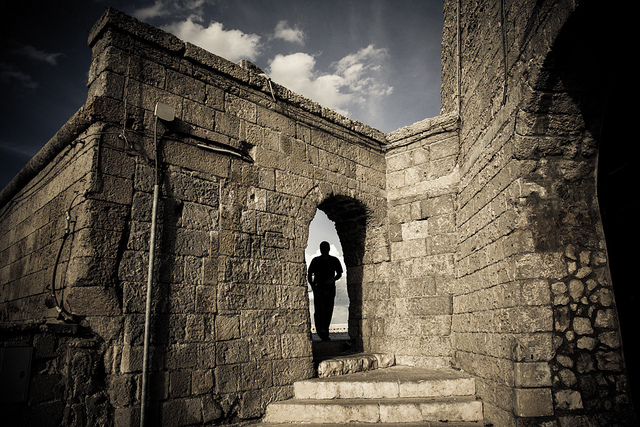 person standing in doorway to castle ramparts
