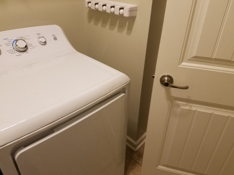 Showing dryer with barely any clearance for door into laundry room