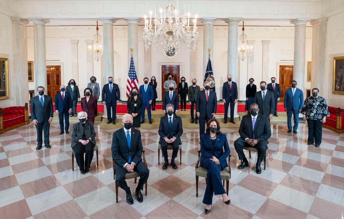 Photo of Joe Biden and cabinet members, taken during COVID with everyone wearing masks. In White House, everyone spaces.